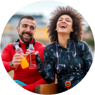 A couple enjoying fruit flavoured red and yellow color drinks in their hands